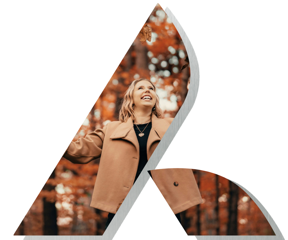 Woman smiling looking up at falling autumn leaves